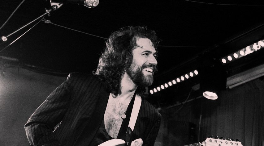 a black and white picture of felix hagan playing guitar