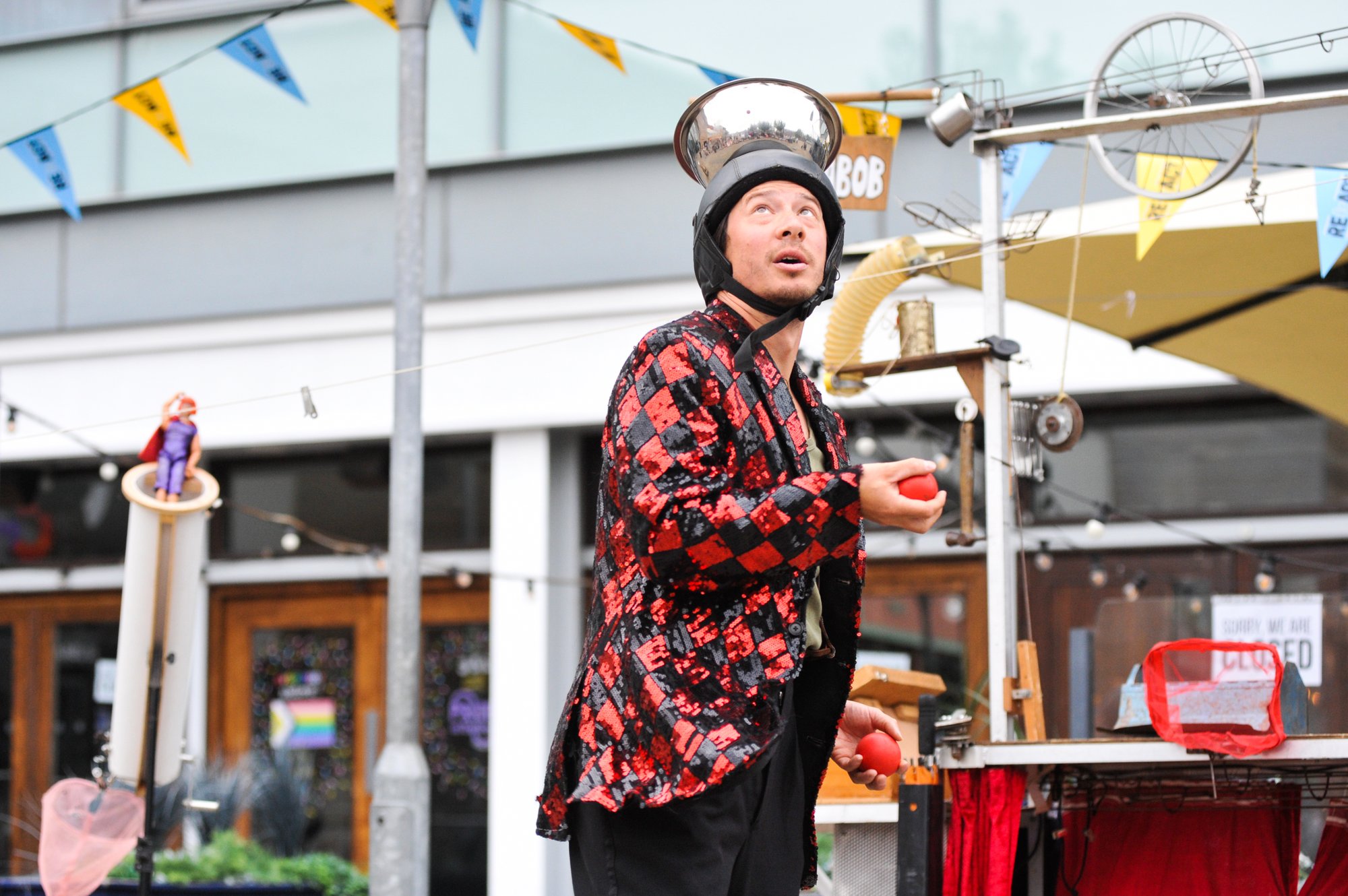 Man in red and black jacket with bowl on his head