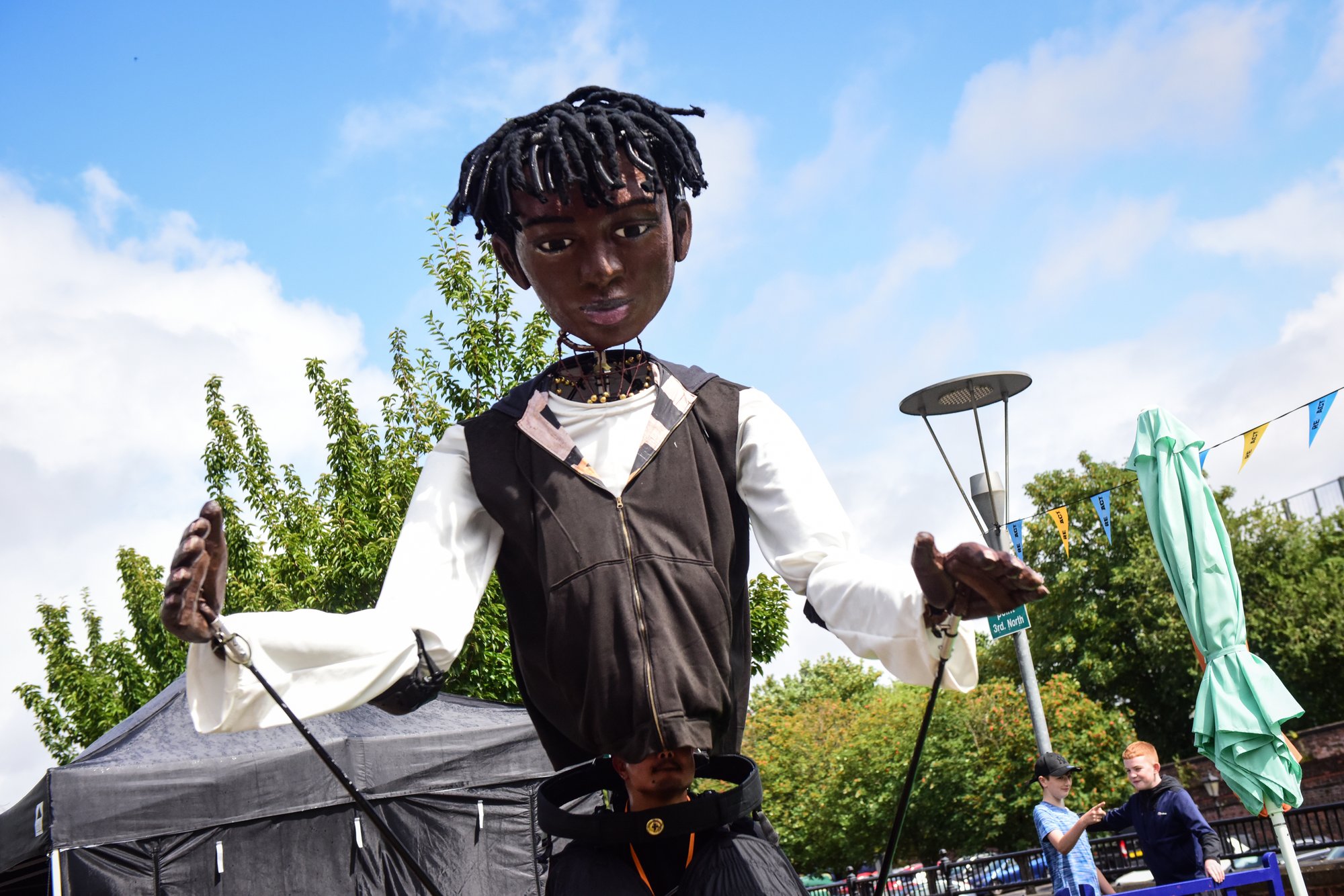 Large puppet dancing against blue sky